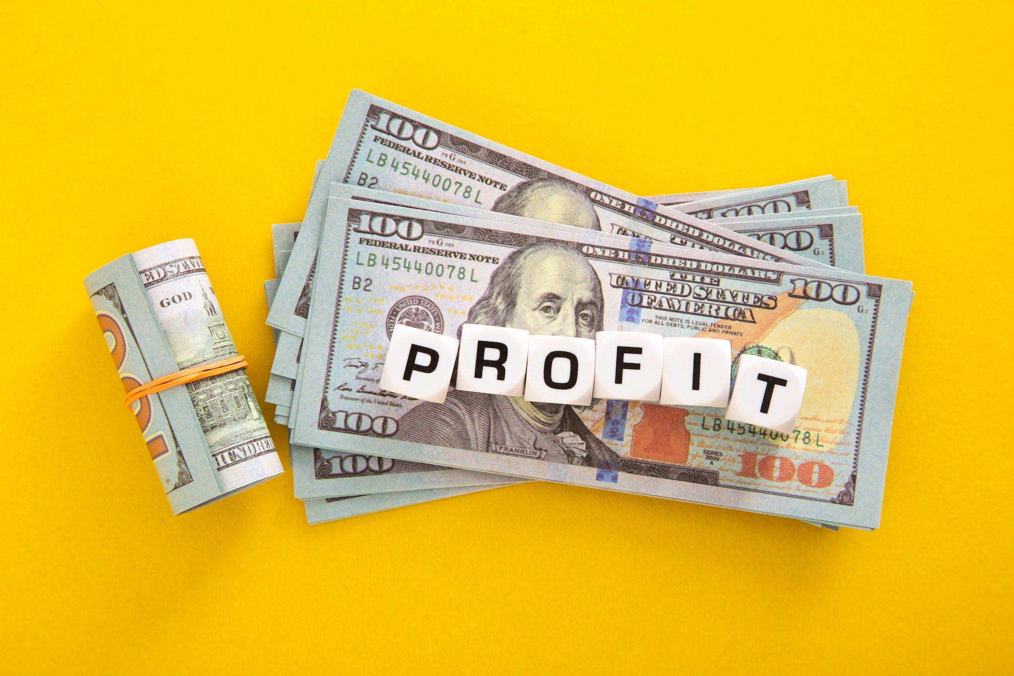 Profit word with stack of Usd on yellow background. Business Profit